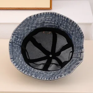 Detail view of denim bucket hat with internal black reinforcement and precise stitching