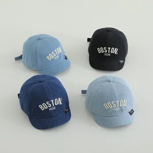 Detailed flat lay of four denim baseball caps in light blue, dark blue, navy, and black