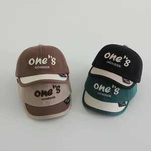 Vista plana de gorras de béisbol de algodón con bordado ONE para niños pequeños en varios colores