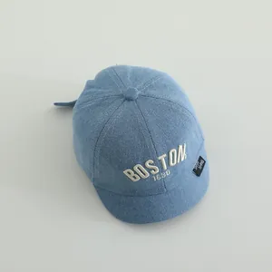 Detailed close-up of light blue denim baby baseball cap with Boston 1630 embroidery