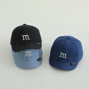 Detailed trio of denim baseball caps in black and blue with embroidered 'M' logo