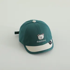 Detail der Baby-Baseballkappe mit Bärenstickerei und Kontrastschirm in Dunkelgrün