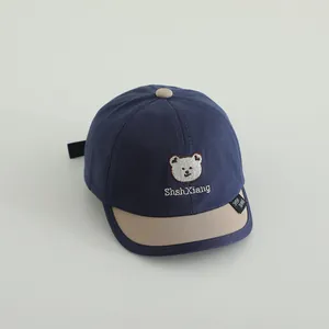 Detailaufnahme der Kinder-Baseballkappe mit Bärenstickerei und gewebtem Etikett-Design
