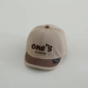 Primer plano de gorra infantil con bordado ONE y textura de algodón de alta calidad