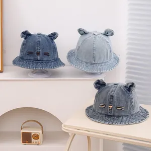 Detailed close-up of blue denim baby bucket hats with cute 3D ears and cat embroidery