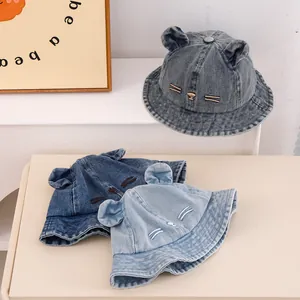 Detailed view of three blue denim kids bucket hats with bear ears and whiskers