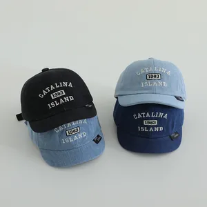 Detailed close-up of four assorted denim baseball caps featuring white vintage embroidery
