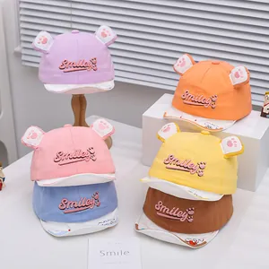 Macro shot of colorful cotton baby baseball caps with cute bear ears and Smiley embroidery