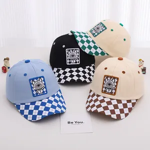 Detail of multi-color kids baseball caps featuring checkerboard brims and cartoon dog patches