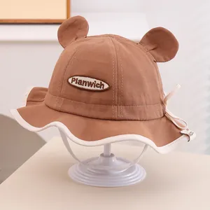 Vue détaillée du chapeau de soleil bébé avec oreilles d'ours et patch brodé