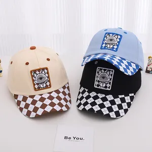 Detailed close-up of three kids baseball caps in light blue, black and beige with dog patches