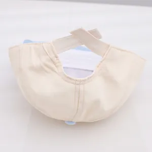 Detail of adjustable velcro strap and cotton canvas texture on the beige baby baseball cap