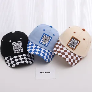 Detailed view of three children baseball caps featuring checkerboard brims and puppy patches