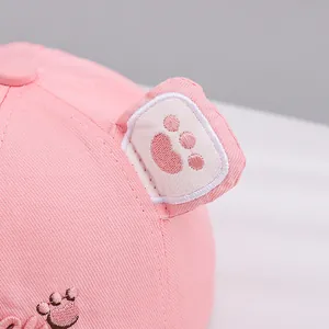 Close-up of pink baby baseball cap featuring 3D animal ears and detailed embroidery