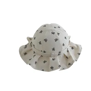 Kids wide brim sun hat with ruffle edge and black bow print in cream cotton fabric