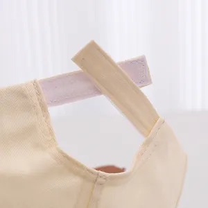 Close-up of adjustable velcro strap and cotton canvas texture on beige kids baseball cap