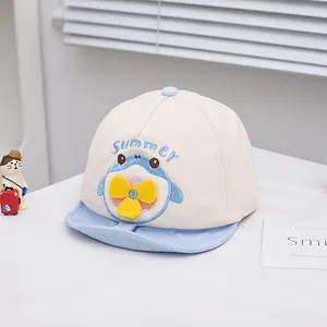 Close-up of beige baby baseball cap featuring blue cartoon shark and Summer embroidery