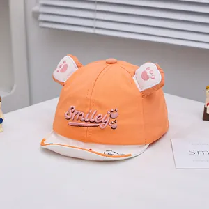 Close-up of orange baby baseball cap featuring 3D ears and Smiley embroidery detail
