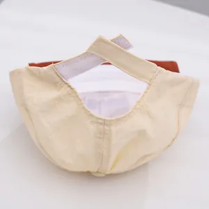 Detail of adjustable hook-and-loop strap on a light beige baby baseball cap