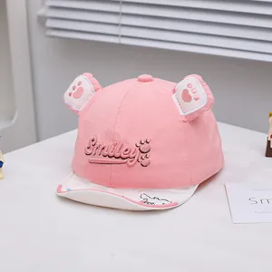 Detail of pink cotton baby cap with Smiley embroidery and cute 3D animal ears