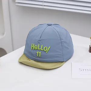 Detail of baby baseball cap with HELLO 11 embroidery and soft adjustable brim
