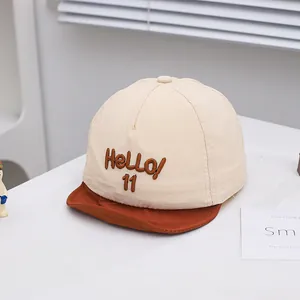 Close-up of baby baseball cap featuring HeLLO 11 embroidery and soft cotton texture