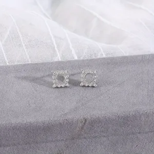 Elegant silver geometric square earrings with micro-set zircons on a gray velvet stand