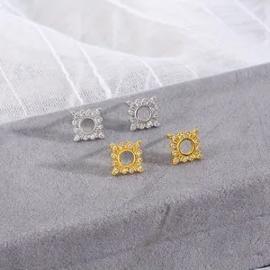 Macro shot of square zircon stud earrings with sunburst border in gold and silver plating
