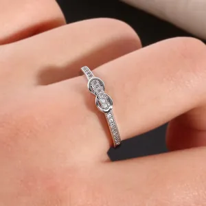 Gros plan d'une bague infini en argent sertie de zircons sur le doigt d'un mannequin