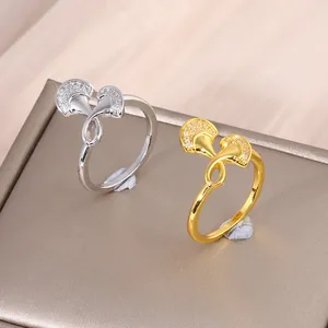 Elegant gold and silver ginkgo leaf rings with micro-set zircon on matte jewelry box