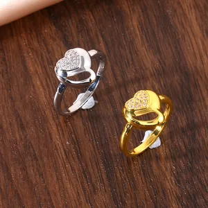 Detail showing gold and silver heart-shaped rings with micro-pave zircons on a silk backdrop