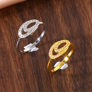 Confronto dettagliato di anelli a doppio ovale oro e argento con micro-pavé di zirconi