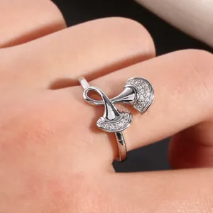 Macro shot of silver ginkgo leaf ring with micro-paved zircons worn on finger