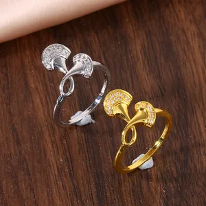 Macro detail of silver and gold ginkgo leaf rings with micro-paved cubic zirconia