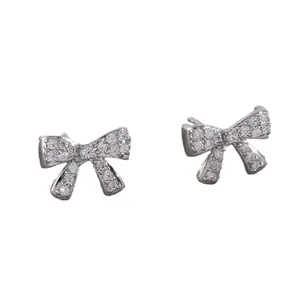 Sparkling copper bow stud earrings with micro-set zircons on a clean white background