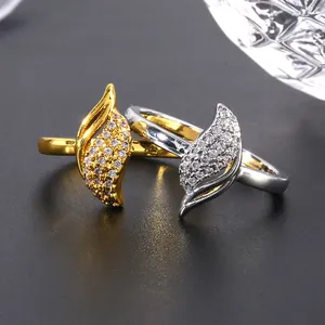Luxurious leaf-shaped rings in gold and silver set with zircons on a black background