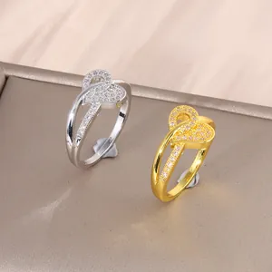 Bagues cœur entrelacées en or et argent avec micro-pavage de zircons sur présentoir