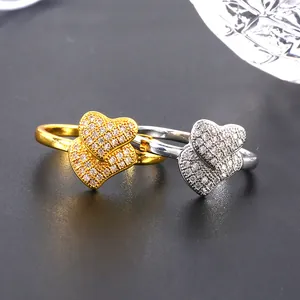 Elegante dubbele hartringen in goud en zilver met micro-pave zetting en zirkoonsteen