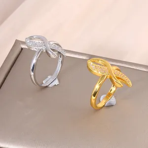 Crossed infinity rings in gold and silver finish with pavé set zircon crystals