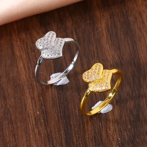 Macro-detail van overlappende dubbele hartringen met micro-pave zirkonen in goud en zilver