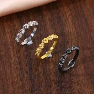 Three-piece ring set in gold, silver, and black with pave-set zircon heart accents