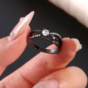 Detail van een zwarte gelaagde infinity ring met centrale witte zirkoon en micro-pave