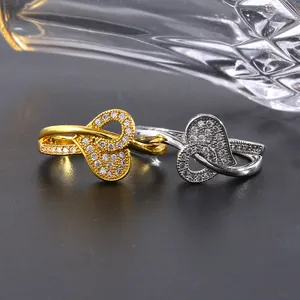 Détail de bagues en cuivre avec zircons micro-pavés en motifs de cœur or et argent