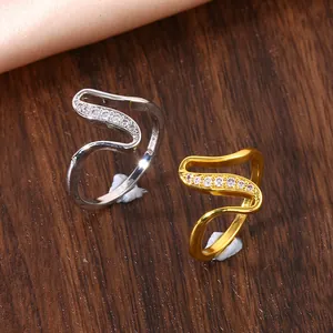Detailed macro of wave-shaped open rings with pavé cubic zirconia in gold and silver