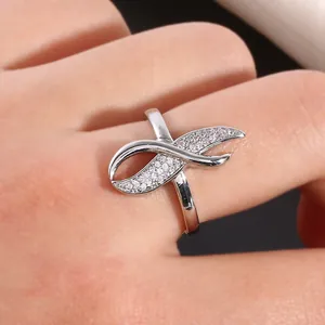 Macro detail of silver cross ring featuring pavé-set cubic zirconia infinity design