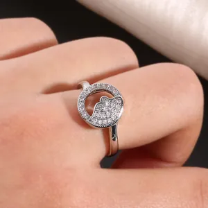Nahaufnahme von silbernem Sonne-Mond-Paarring mit Pavé-Zirkonia-Inlay am Finger