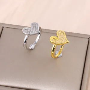 Gold and silver heart-shaped rings with micro-pave cubic zirconia on a jewelry display