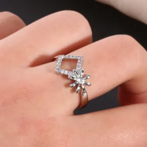 Dettaglio macro di un anello a fiore geometrico in argento con zirconi incastonati