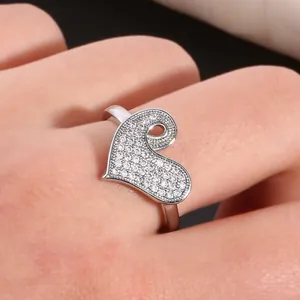 Macro shot of silver heart ring with micro-paved cubic zirconia stones on fingers