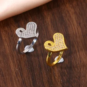 Macro detail of gold and silver heart rings with micro-pave zircons on wood surface